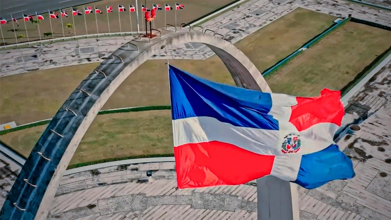 a flag flying in the air next to a bridge